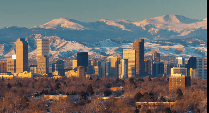 The Denver skyline with the Rocky Mountains in the background.