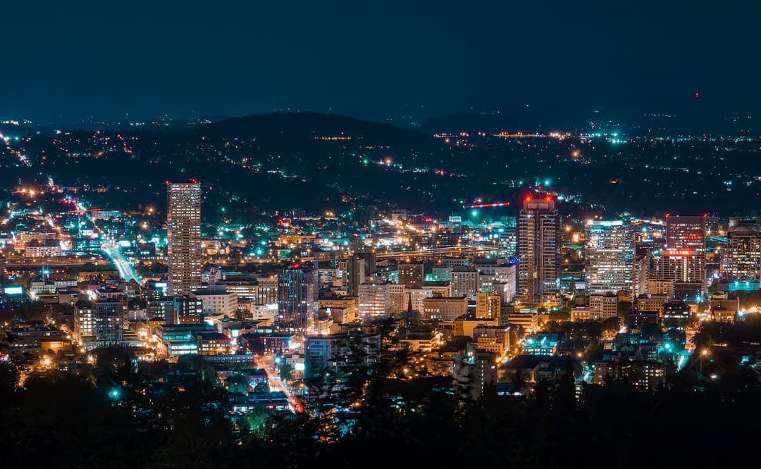 Downtown Portland glowing at night below the West Hills.